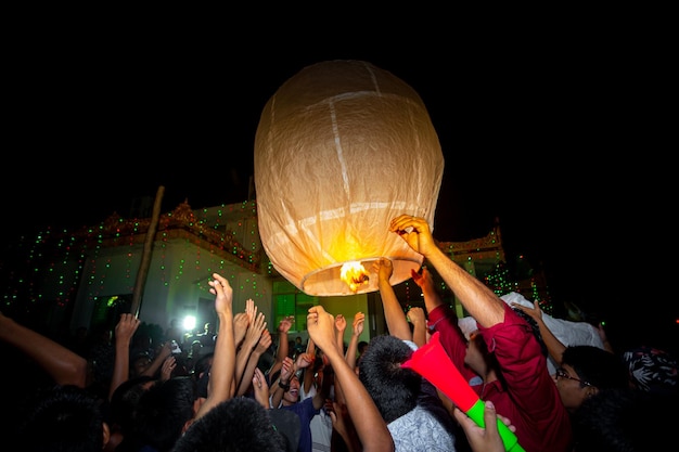 Foto bangladesh, 13 de octubre de 2019, la familia de devotos budistas libera linternas del cielo para adorar las reliquias de buda en el festival probarona purnima en bandarban, bangladesh