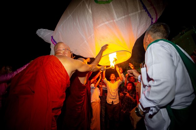 Foto bangladesh 13 de octubre de 2019 un monje budista con sus discípulos tratando de volar una linterna de papel en el templo budista ujani para en bandarban bangladesh