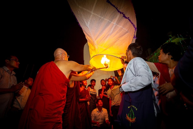 Bangladesh 13 de octubre de 2019 Un monje budista con sus discípulos tratando de volar una linterna de papel en el Templo Budista Ujani Para en Bandarban Bangladesh