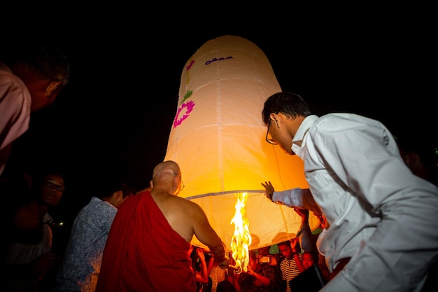 Bangladesh 13 de octubre de 2019 Un monje budista con sus discípulos tratando de volar una linterna de papel en el Templo Budista Ujani Para en Bandarban Bangladesh