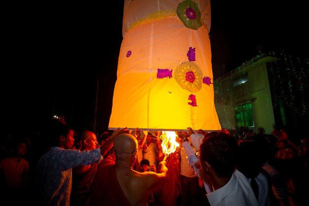 Bangladesh 13 de octubre de 2019 Un monje budista con sus discípulos tratando de volar una linterna de papel en el Templo Budista Ujani Para en Bandarban Bangladesh