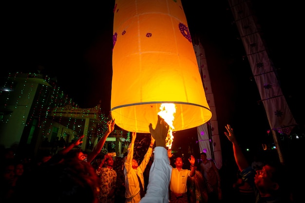 Bangladesh 13 de octubre de 2019 Un monje budista con sus discípulos tratando de volar una linterna de papel en el Templo Budista Ujani Para en Bandarban Bangladesh