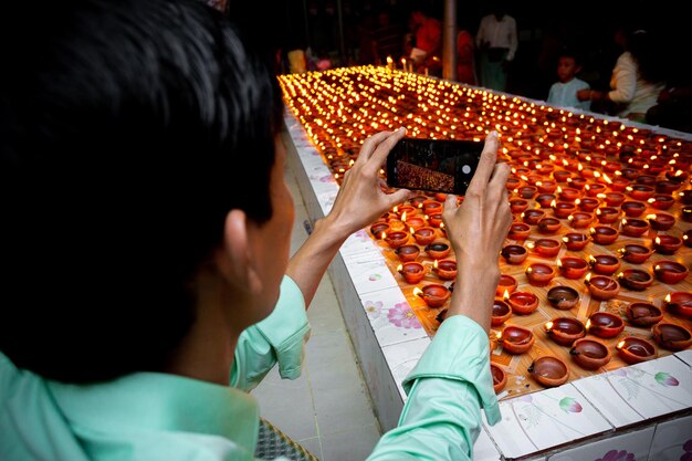 Foto bangladesh 13 de octubre de 2019 un visitante tomó una foto de una lámpara de aceite de arcilla encendida con su teléfono móvil en bandarban bangladesh