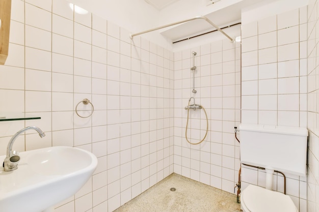Banheiro bem iluminado com azulejos brancos em todas as paredes