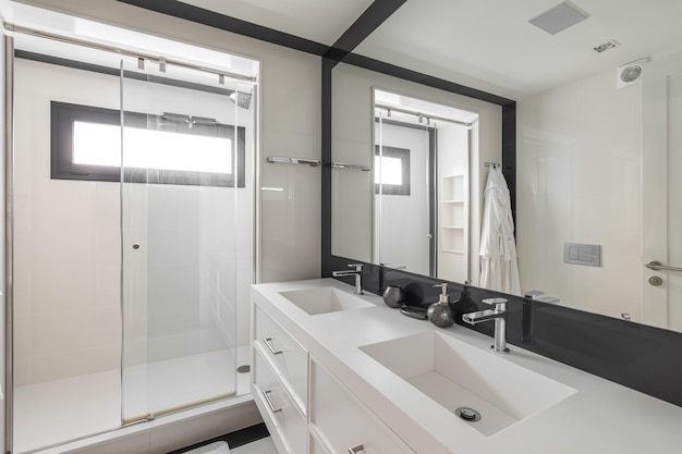 Banheiro branco com chuveiro duas pias e espelho de moldura preta Interior moderno do apartamento remodelado