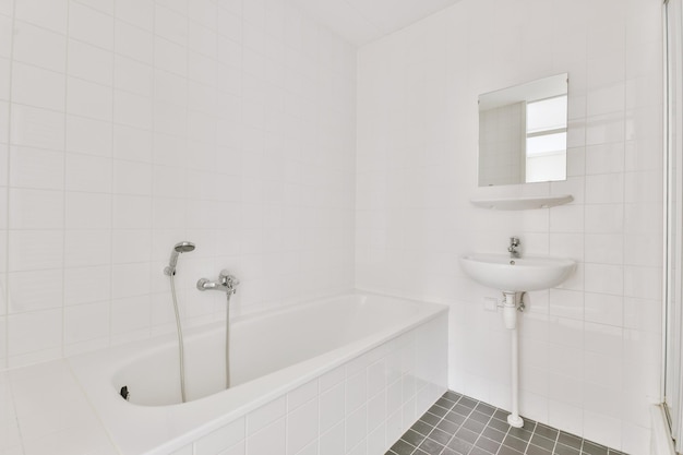 Banheiro com azulejos brancos e pretos e banheira de cerâmica e pia sob o espelho em uma casa moderna