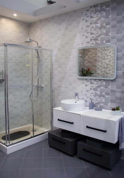 Banheiro espaçoso em tons de cinza com piso aquecido, box amplo, pia dupla e pia dupla