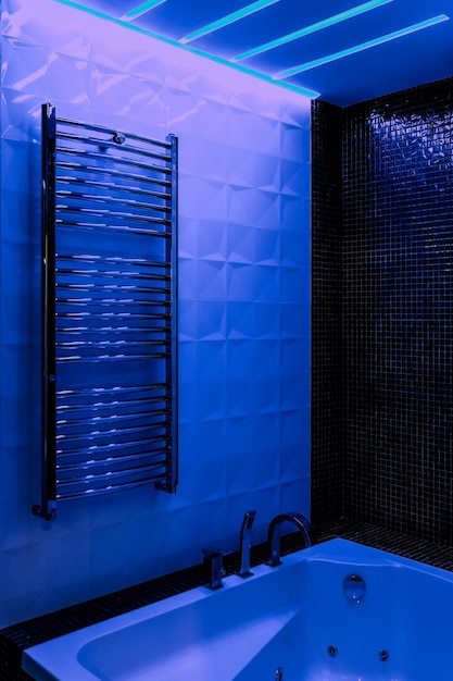 Banheiro moderno com banheira autônoma, torneiras modernas e iluminação ambiente em LED azul