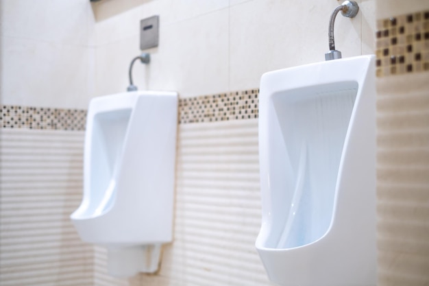 Banheiro público masculino Closeup moder mictórios brancos no banheiro masculino design de mictórios de cerâmica branca para homens