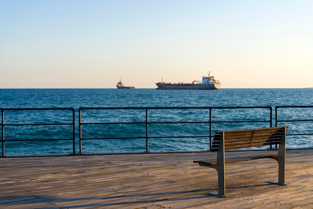 Bank auf Holzboden mit Blick aufs Meer