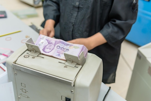 Bankangestellte Baht Banknotenzählung mit der Maschine