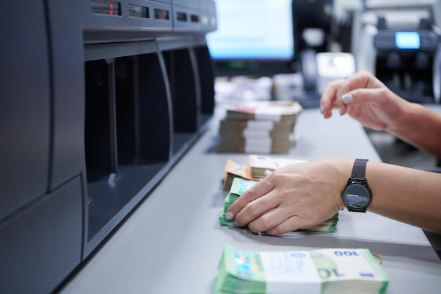 Foto bankangestellte nutzen eine geldzählmaschine, während sie papierbanknoten im banktresor sortieren und zählen. große geldbeträge auf der bank