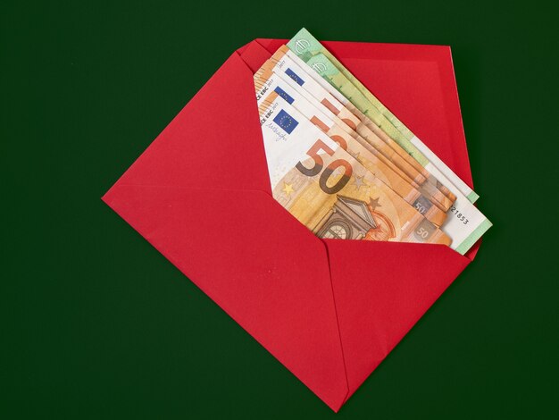 Banknoten in einem roten Umschlag auf einem grünen Hintergrund