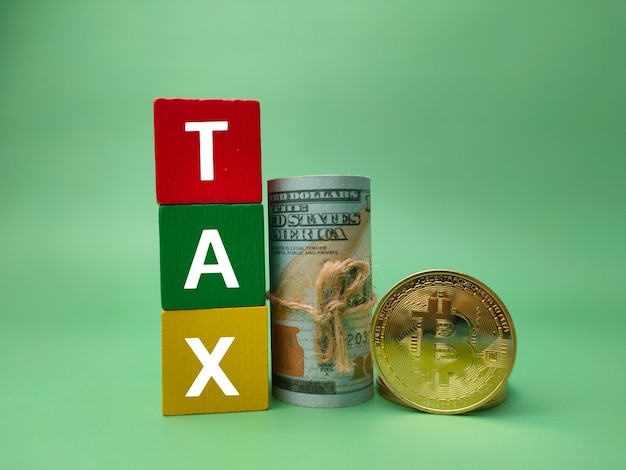 Banknotesbitcoins e cubo de madeira colorido com a palavra TAX no conceito de negócio de fundo verde