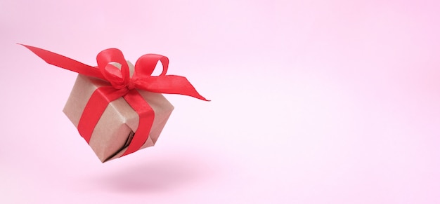 Banner con caja de regalo cinta roja en rosa.