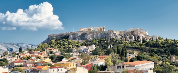 Banner, colina de la Acrópolis con templos antiguos y techos de casas en Atenas, Grecia, en un día brillante con cielo azul. Imagen panorámica en tonos.