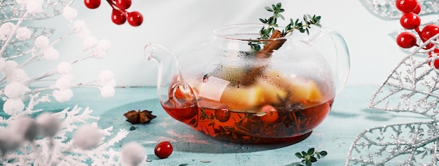 Banner com bebida que aumenta a imunidade Chá de inverno com laranja de cranberries e especiarias em bule de vidro
