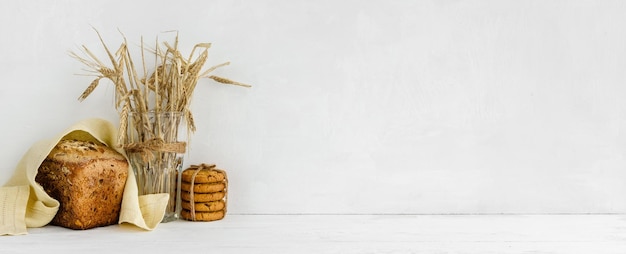 Banner com fundo de parede branca e espaço de cópia Pão de grãos caseiro e um guardanapo de linho Decoração de cozinha em casa