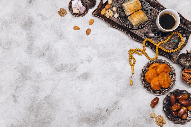 Banner com pratos árabes tradicionais e conjuntos de comida sobre ele Alcorão e rosário Vista superior da mesa do Ramadã