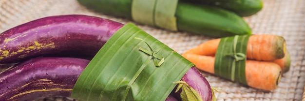 Banner concepto de embalaje de productos ecológicos de formato largo verduras envueltas en una hoja de plátano como un