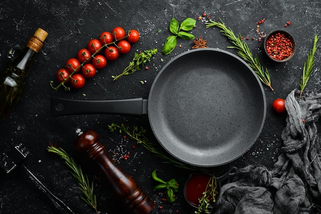 Banner culinario Sartén con verduras sobre un fondo de piedra negra Vista superior Estilo rústico