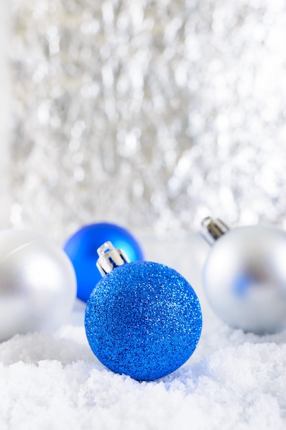 Banner de ano novo com bolas de Natal azuis, prata e brancas na neve em fundo abstrato de inverno. Decoração de Natal com espaço de cópia. Feliz Natal.