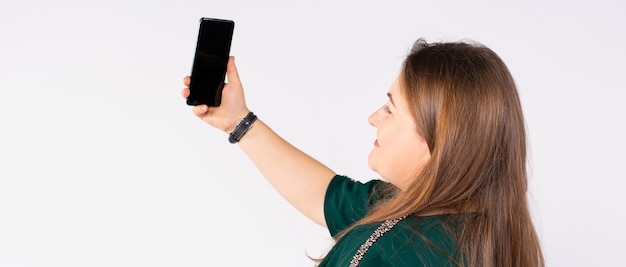 Banner de formato longo, uma mulher fazendo selfie uma linda mulher com um vestido verde com um telefone nas mãos