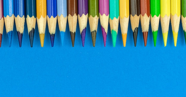 Banner de fundo de borda de lápis de cor com espaço de cópia, foto de vista de topo de mesa de escritório em azul