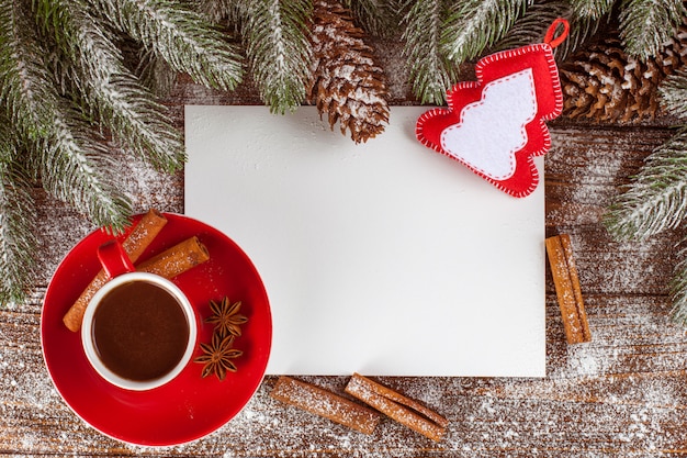 Banner de natal com árvore verde, cones, copo vermelho com chocolate quente, decorações de feltro artesanal