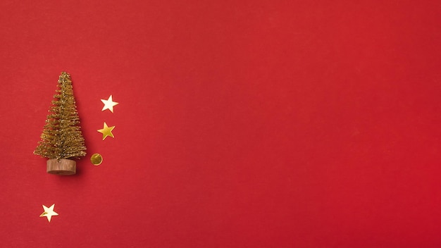 Banner de natal com confete dourado de natal e pequena árvore de natal dourada decorativa ano novo