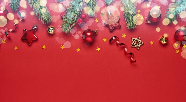 Banner de Natal. Ramos de abeto e decorações de Natal em um fundo vermelho com bokeh.