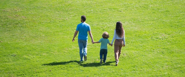 Banner de primavera com família feliz vista traseira da mãe, pai e filho, caminhando ao ar livre no parque de verão