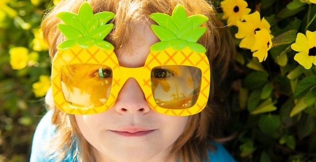 Banner de primavera e criança para o cabeçalho do site, vibrações loucas de verão, criança fofa em óculos de sol de festa