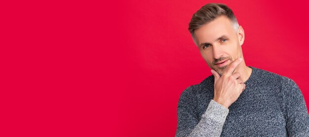 Banner de retrato de rosto de homem com espaço de cópia cara grisalho de suéter em fundo vermelho retrato de homem grisalho com barba modelo de moda masculina