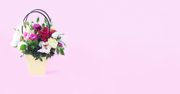 Banner der Geschenkbox mit schönem Blumenstrauß (Rose, Eustoma, Freesie) auf hellrosa Hintergrund