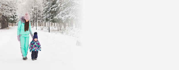 Banner feliz familia Madre e hijo niña en un paseo de invierno en la naturaleza con espacio de copia