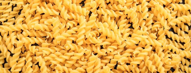 Banner de fondo de textura de pasta de forma de espiral fusilli sin cocer