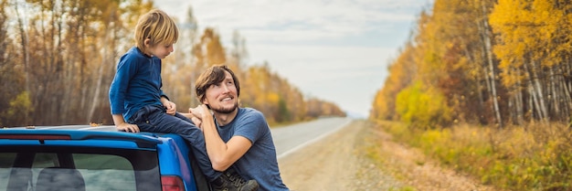 Banner de formato largo, papá e hijo descansan al costado de la carretera en un viaje por carretera con