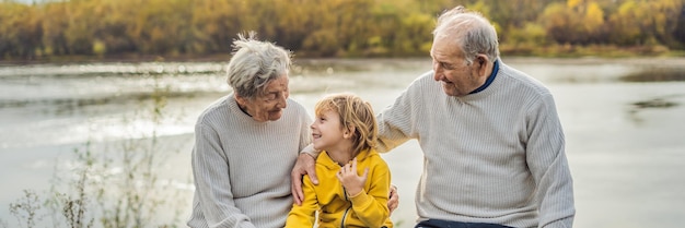 Banner de formato largo pareja senior con nieto en el parque de otoño bisabuela