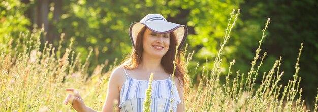 Foto banner-frau, die an sonnigen sommertagen zwischen wildblumen spazieren geht, kopieren sie das raumkonzept der freude an der kommunikation