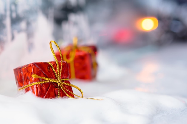 Banner de guirnalda de nieve de regalo rojo de Navidad. Fondo borroso festivo colorido de Año Nuevo con bokeh.