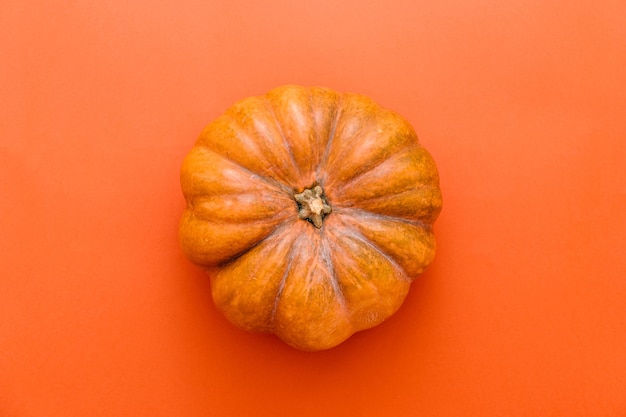 Banner de Halloween de vacaciones con calabaza sobre fondo naranja oscuro. Vista superior