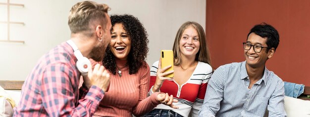 Foto banner horizontal ou cabeçalho com jovens estudantes universitários se divertindo no salão do campus ouvindo música e brincando com celular conceito de rede social com meninos e meninas da geração z