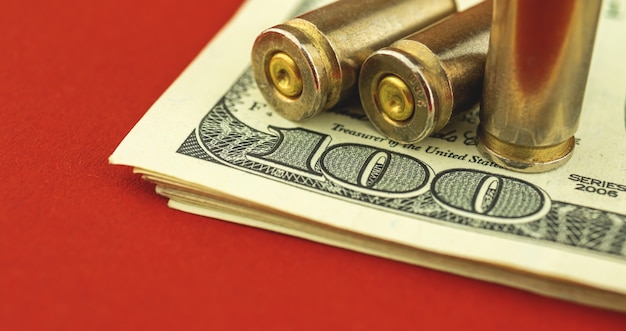Banner ilegal de comércio de munições, venda de armas, conceito de financiamento do terrorismo, nota de dólar UD e bala no fundo