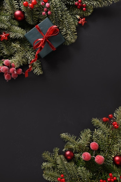 Banner de invierno de Navidad con ramas de abeto bolas rojas sobre fondo negro Tarjeta de felicitación de Navidad