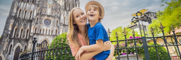 Foto banner long format jovens turistas mãe e filho no fundo da catedral de são josé em hanoi vietnã reabre após quarentena de coronavírus covid-19