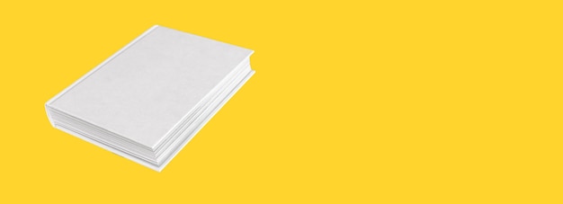 Banner con maqueta de libro con tapa blanca vacía sobre fondo amarillo Vista de ángulo Concepto de educación de estudio de lectura Enciclopedia Biblia código novela Espacio de copia