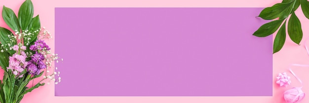 Banner mit Blumenstrauß auf rosa lila Hintergrund flach gelegt Kopierbereich Draufsicht Konzept Hallo Frühling Muttertag Frauentag Guten Tag Vorlage für Text und Design