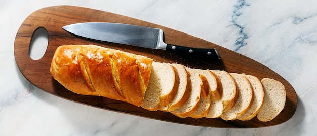 Banner mit geschnittenem Brot auf einem Schneidebrett und einem Kochmesser auf einem Marmortisch