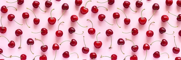 Banner mit Muster aus roten Süßkirschbeeren auf rosa Hintergrund Flache Ansicht von oben